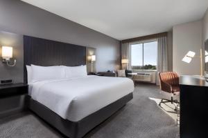 卡尔斯巴德Holiday Inn Carlsbad/San Diego, an IHG Hotel的酒店客房设有一张大床和一张书桌。