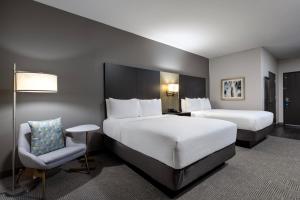 卡尔斯巴德Holiday Inn Carlsbad/San Diego, an IHG Hotel的酒店客房,配有两张床和椅子
