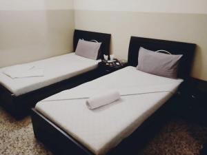 卡拉奇Four Season 1 Airport Guest House的两张睡床彼此相邻,位于一个房间里