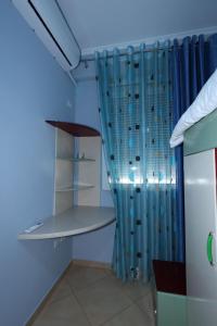 培拉特Rio's Apartment的一间卧室配有蓝色窗帘和架子