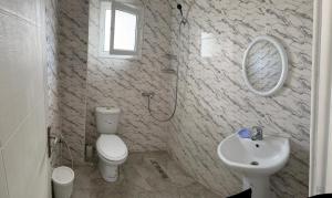 米多恩Dyar Amina的浴室配有白色卫生间和盥洗盆。
