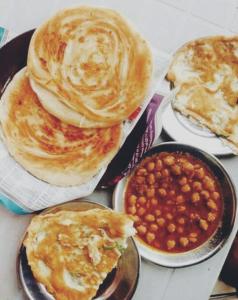 卡拉奇Four Season 1 Airport Guest House的一组食物,包括煎饼和豆子