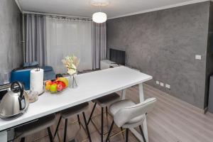 维勒班Appartement moderne, proche du Parc de la tête d'Or et de Lyon的厨房配有白色的桌子和凳子