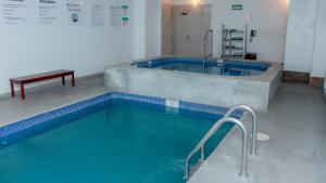 奥夫雷贡城Holiday Inn Express & Suites - Ciudad Obregon, an IHG Hotel的客房内设有一个大型游泳池及浴缸