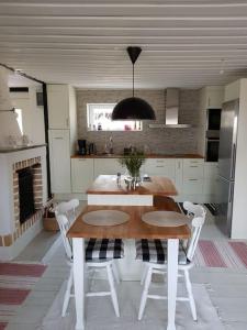 尼雪平Ekbacken - naturskön stuga med närhet till havet的厨房配有木桌和白色椅子