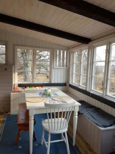 尼雪平Ekbacken - naturskön stuga med närhet till havet的客房设有白色的桌子、椅子和窗户。