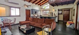 雅科Casa Gris in Jaco的一间带棕色沙发的客厅和一间厨房