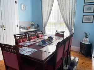 德文港Stony Rise Cottage B&B的一间带长桌和椅子的用餐室