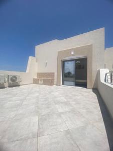 乌姆苏克Villa Oasis Djerba的一座大型建筑,设有大型混凝土庭院