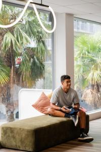 奥克兰Haka House Auckland City的坐在窗前沙发上的人