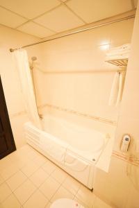 龙川市华平1号酒店的白色的浴室设有浴缸和卫生间。