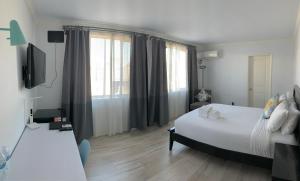 洛杉矶Hometel Suites的卧室设有一张白色大床和一扇窗户。