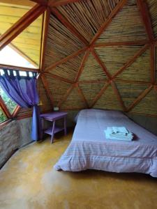 卡法亚特Casa Arbol Domos的木屋顶客房的一张床位