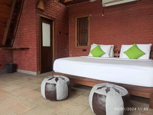 KadugannawaThe Cloud Resort的一间卧室设有一张大床和砖墙