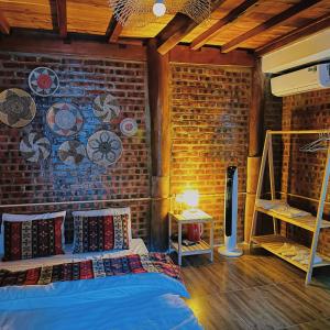木州县Homestay Cánh Đồng - Lều Camping & Coffee的一间卧室设有砖墙和一张带枕头的床