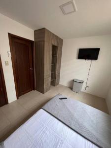 萨利纳斯Casa con piscina Punta Carnero的一间卧室配有一张床和一台电视