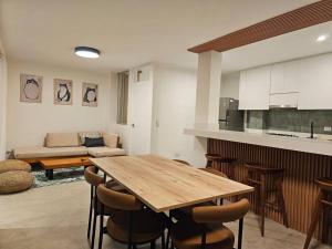 普库萨纳Hermoso dúplex con gran vista!的厨房以及带木桌和椅子的客厅。