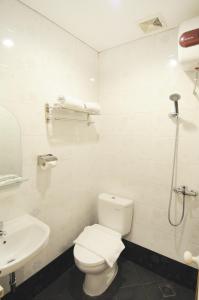 SukaramiRuma Ruma Hotel Kenten - Palembang的白色的浴室设有卫生间和水槽。