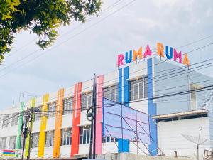 SukaramiRuma Ruma Hotel Kenten - Palembang的建筑物的侧面有色彩斑 ⁇ 的标志