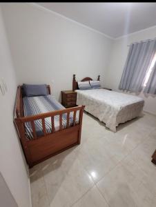 塞拉内格拉Casa das posses para 8 pessoas的一间带两张床的卧室,铺有瓷砖地板。