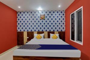 勒克瑙SPOT ON Hotel C S Tower的一间卧室配有一张蓝色和红色墙壁的床