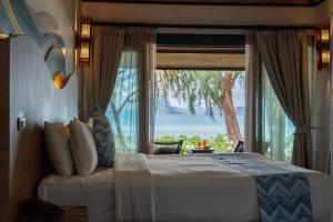 塔可克海滩Tup Kaek Sunset Beach Resort-SHA Plus的一间卧室设有一张床和一个大窗户