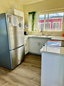 WaialuaMokulē'ia Beach Houses at Owen's Retreat的厨房配有不锈钢冰箱和白色橱柜
