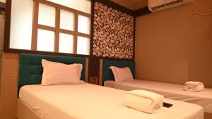 SonāmuraHotel Maisha International的客房设有两张床和窗户。