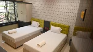SonāmuraHotel Maisha International的一间设有两张床的客房,