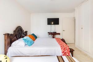 巴兰基亚Hermoso Apartamento Riomar的一间卧室设有两张床,墙上配有电视。