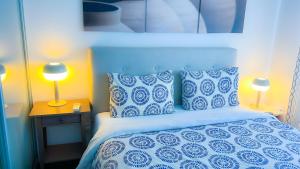 利马索尔Panoramic Sea View Apt - 2bed的一间卧室配有一张带蓝色和白色枕头的床