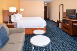 奥兰多奥兰多机场费尔菲尔德客栈的酒店客房配有床、沙发和电视。