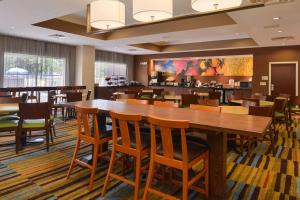 奥兰多奥兰多机场费尔菲尔德客栈的用餐室配有大型木桌和椅子