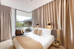 卡马拉海滩Twinpalms MontAzure的卧室配有白色的床和带窗帘的窗户