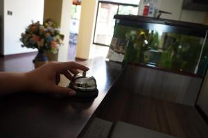 圣萨尔瓦多Villa Las Flores的手握着一个钟表坐在桌子上