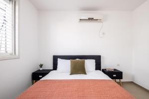 内坦亚Poleg Serenity Villa by Sea N' Rent的卧室配有带白色墙壁和窗户的床
