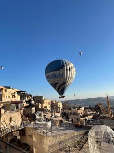 乌奇希萨尔Karlık Cave Suite Cappadocia的飞过城市的热气球