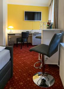 莱比锡克劳塞维茨卡尔酒店的配有一张床和一张书桌的酒店客房
