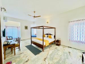 乌代浦Jag Aravali Resort Udaipur- Experience Nature away from city Hustle的一间卧室配有一张天蓬床和一张书桌
