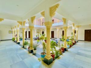 乌代浦Jag Aravali Resort Udaipur- Experience Nature away from city Hustle的大房间,有盆栽植物和柱子