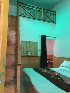 马拉里iSaint's Kuteer的一间卧室配有一张双层床和绿色的床罩