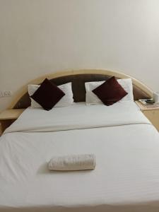 贾巴尔普尔Hotel Cozy Residency的一张白色的大床,上面有毛巾