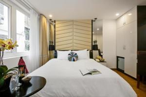 河内Splendid Holiday Hotel Spa的卧室配有一张白色的大床和一张桌子