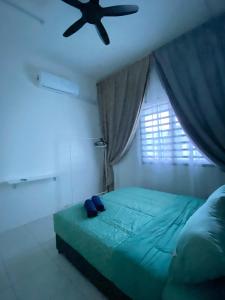 斯里伊斯兰德Abu Fateh Homestay的一间卧室配有一张带吊扇的床
