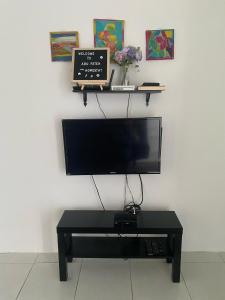 斯里伊斯兰德Abu Fateh Homestay的壁挂式平面电视和桌子