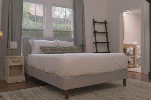 拉斐特Clinton House的卧室配有一张带白色床单和枕头的大床。