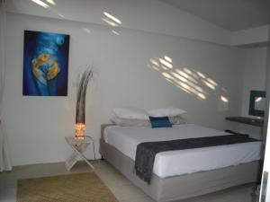 甘地达萨水族生态度假酒店的卧室配有一张床,墙上挂有绘画作品