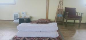 PanaotiDadaghare Homestay & View Point Restaurant的地毯上有一堆毯子的房间