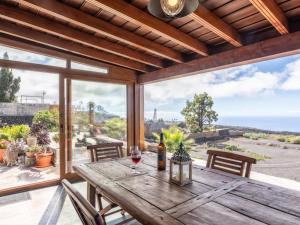 洛斯·亚诺斯·德·阿里丹Casa Pedrito - Cozy House, dreamy Terrace & Sea views的天井上的木桌,佐以一杯葡萄酒