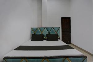 坎普尔SPOT ON Shree Sarveshwar Party Lawn And Hotel的一间卧室配有一张带黑色枕头的大床
